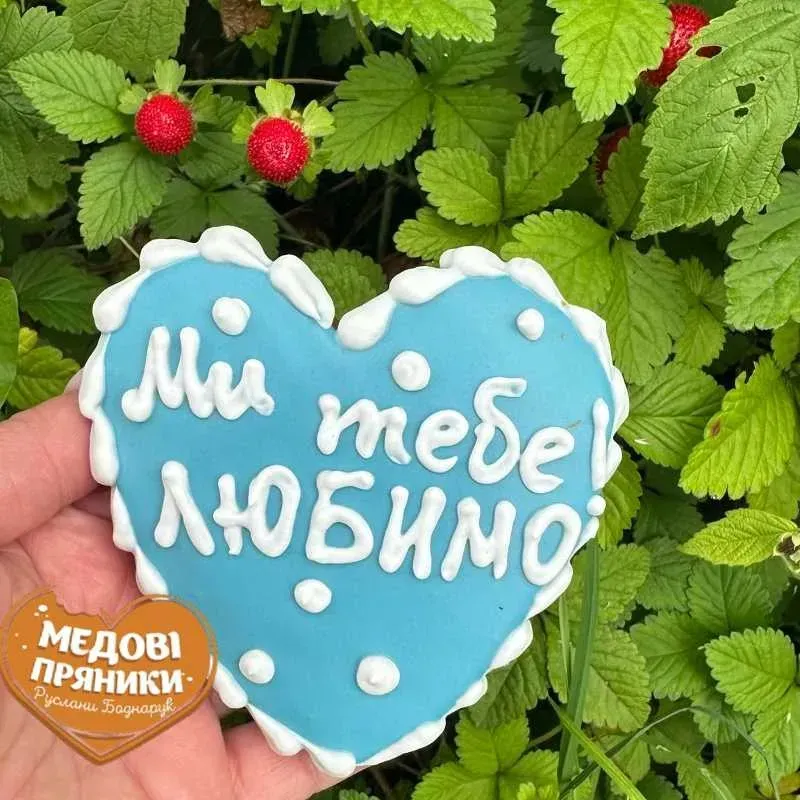 Пряник сердечко блакитного кольору з написом білою глазурʼю МИ ТЕБЕ ЛЮБИМО! Ручна робота.