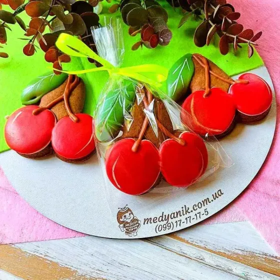 Три пряника на кожному з яких дві червоних вишні та зелений листочок. Ручна робота.